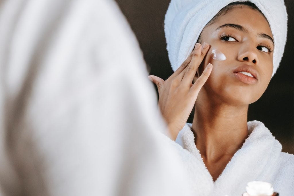 Woman putting on facial lotion on dry skin